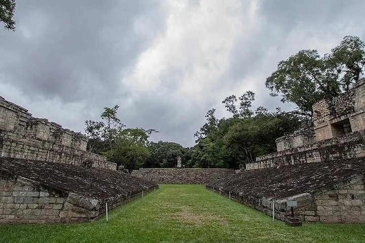 View of the grass-covered Mayan ball court at Copan Ruins