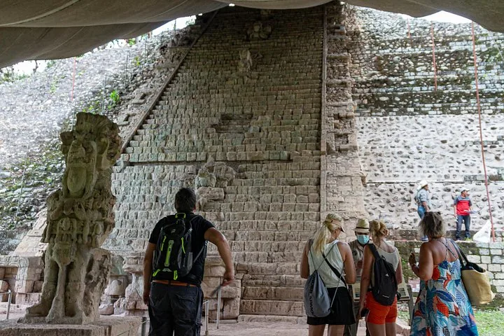 Turisti e una guida in piedi davanti alla Scalinata Geroglifica alle Rovine di Copán
